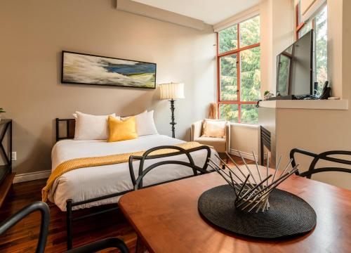 um quarto com uma cama, uma mesa e cadeiras em Alpenglow Lodge Large Studio by MVA em Whistler
