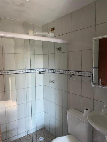 a bathroom with a shower and a toilet and a sink at Recanto Primavera in Boicucanga