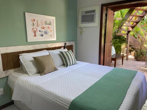 a bedroom with a bed and a door to a patio at Pousada Peixe Espada in Praia do Forte