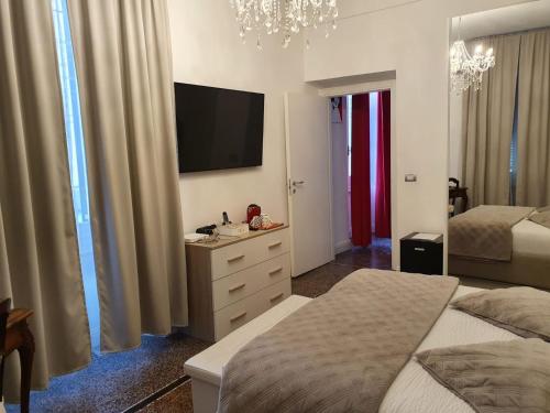 1 dormitorio con 2 camas y TV en la pared en Varazze Suite Sauna e Hammam en Varazze