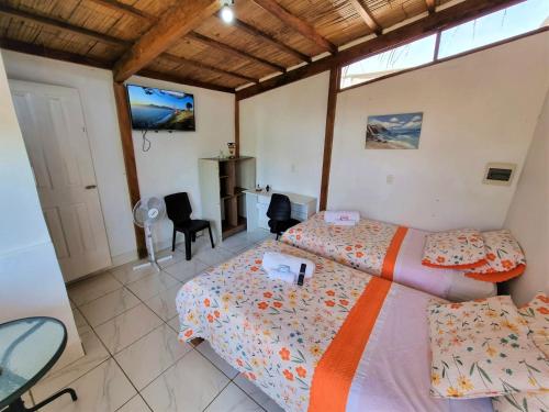 索里托斯的住宿－Bright Bungalows - Frente al Mar，一间卧室配有两张床和一张桌子及椅子