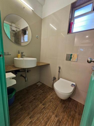 y baño con aseo, lavabo y espejo. en Most convenient 2 BR apartment in central Anjuna, en Anjuna