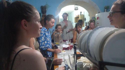 eine Gruppe von Menschen, die um einen Tisch mit Weingläsern stehen in der Unterkunft Casa dei fiori in Syrakus