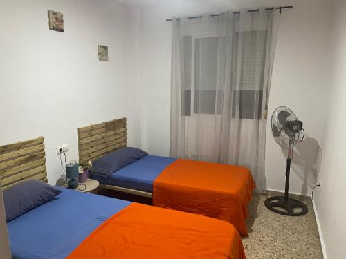 a bedroom with two beds and a fan and a fan at Edificio La Horteta in La Font D´En Carròs