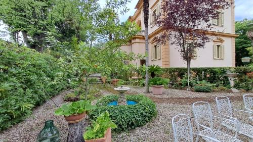 a garden with chairs and a fountain in front of a building at Villa Tessa in Ronciglione