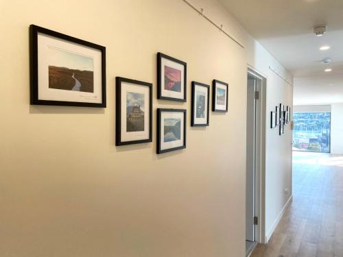 a hallway with framed pictures on a wall at Little Island Apartments in Hobart