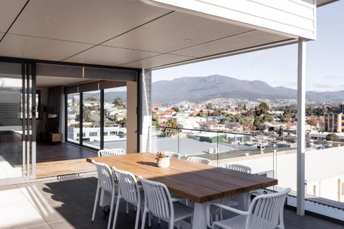 a wooden table and chairs on the balcony of a house at Little Island Apartments in Hobart