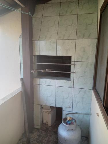La salle de bains est pourvue d'une cheminée et de toilettes. dans l'établissement Alugo quarto, próximo à praia, à Torres