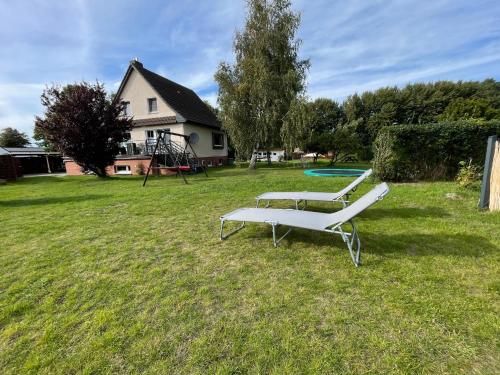 two benches in a yard with a playground at Wohlfuehl-Orte24 am Hafen in Schaprode, Rügen in Schaprode