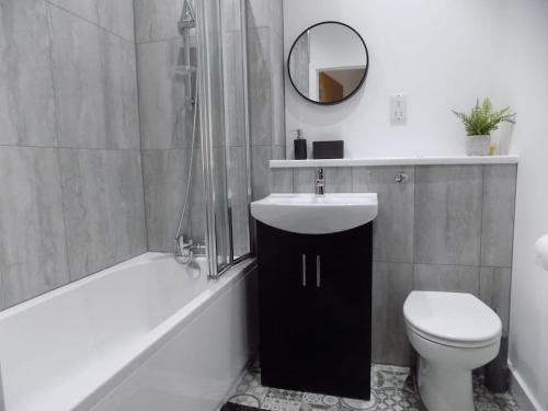 een badkamer met een wastafel, een toilet en een spiegel bij 2 Bedroom Luxury City Centre Apt in Lincoln