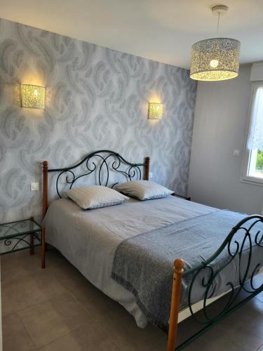 a bedroom with a bed with a metal headboard at Gîte Cadet rousselle in Lessay