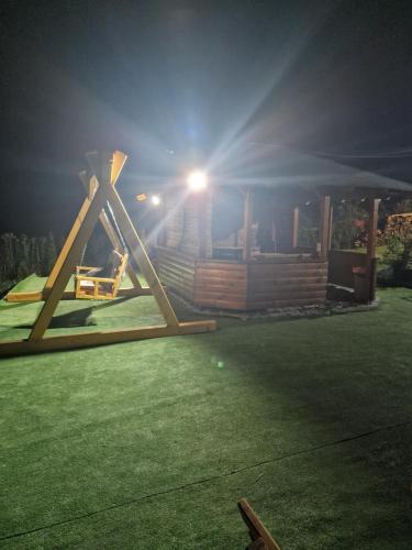 a playground in front of a house at night at Vikendica Chalet Nišići in Ilijaš