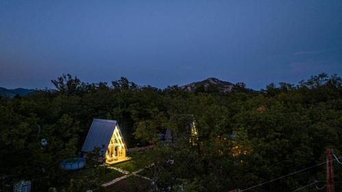 a small house in the middle of a forest at night at Vukova dolina apartments in Cetinje