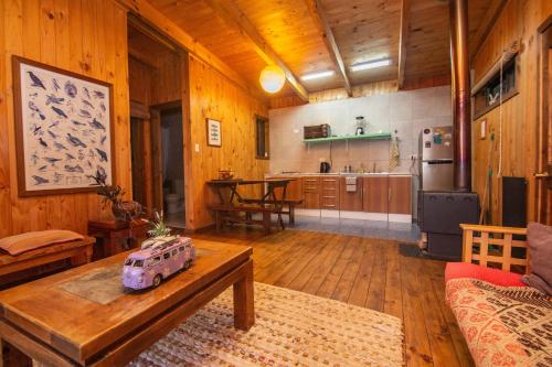 a living room with a table and a kitchen at Cabañas Bosques de Puertecillo in Puertecillo