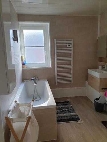 une salle de bain avec une baignoire, un lavabo et une fenêtre dans l'établissement Les falaises d Etretat Etretat hypercentre duplex 50m de la mer & parking, à Étretat