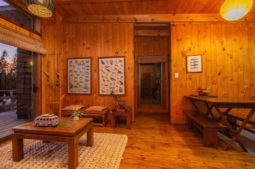 a living room with wooden walls and wooden floors at Cabañas Bosques de Puertecillo in Puertecillo