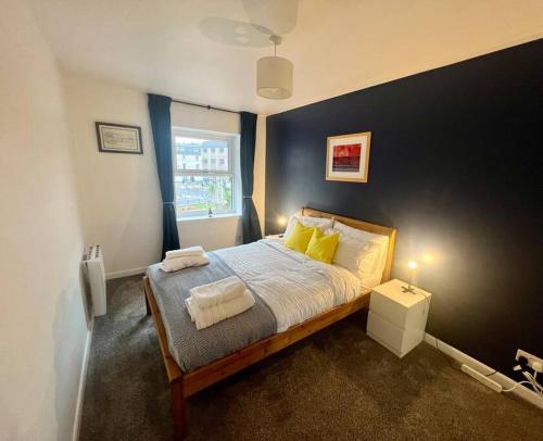 Un dormitorio con una cama con almohadas amarillas y una ventana en 16 Macgregor court, Oban en Oban
