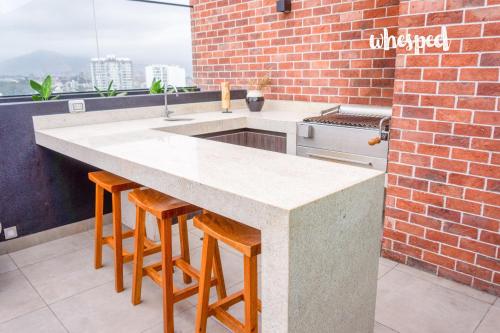 une cuisine avec un comptoir et un mur en briques dans l'établissement Confort & luxury Apt- San Isidro, à Lima