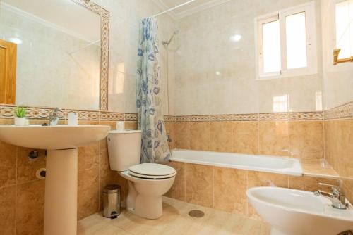 ein Badezimmer mit Toilette, Waschbecken und Badewanne in der Unterkunft Villa Mariposa in Orihuela