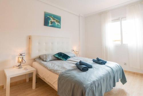 ein Schlafzimmer mit einem Bett mit blauen Handtüchern darauf in der Unterkunft Villa Mariposa in Orihuela