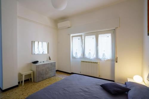 a bedroom with a bed and a sink and two windows at Ca' du Cila in Riomaggiore