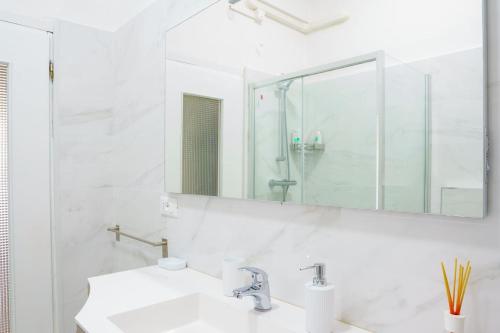 uma casa de banho branca com um lavatório e um espelho em Ca' du Cila em Riomaggiore