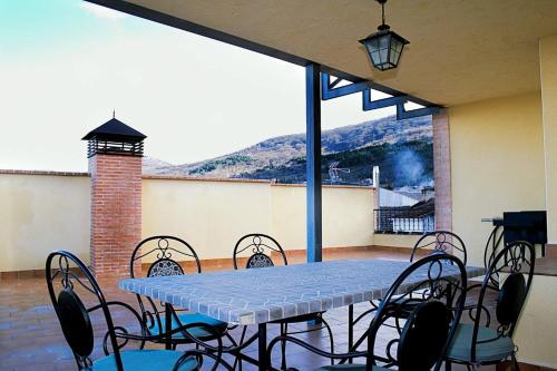 una mesa y sillas en un patio con vistas a la montaña en Casa Rural Cristina III, en San Pablo de los Montes