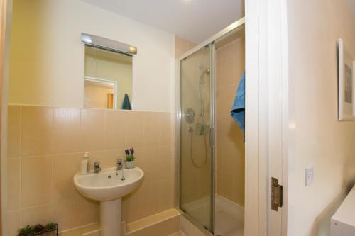 een badkamer met een wastafel en een douche bij Spacious 2 Beds & 2 Baths Flat at City Center in Birmingham