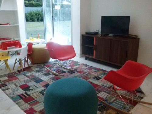 uma sala de estar com cadeiras coloridas e uma televisão em Torre Bellagio piso 14 Hermoso depto 3 personas em Punta del Este