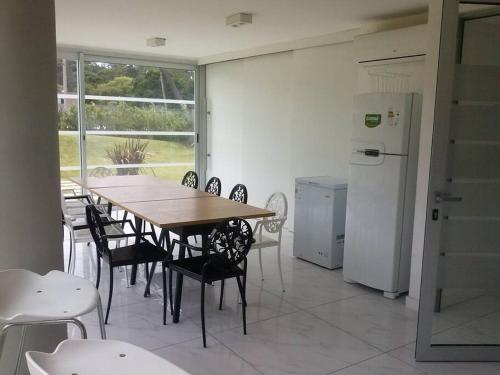 ein Esszimmer mit einem Tisch und Stühlen sowie einem Kühlschrank in der Unterkunft Torre Bellagio piso 14 Hermoso depto 3 personas in Punta del Este