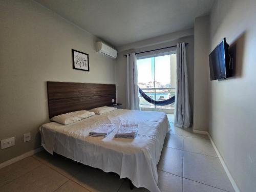 a bedroom with a large bed and a large window at AP encantador na Praia do Forte! Porto Azul (107) in Cabo Frio