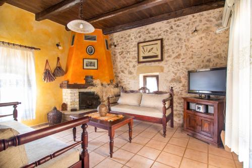 a living room with a couch and a tv at Samonas Traditional Villas in Samonás