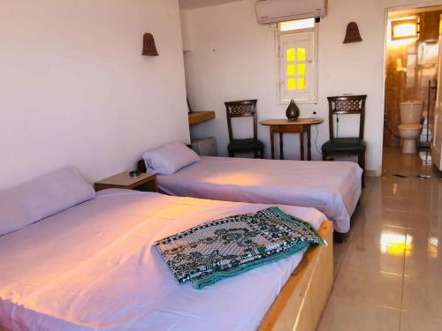 a room with two beds and a table and chairs at فللبررر in Nuweiba