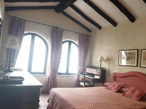 1 dormitorio con 1 cama, 2 ventanas y escritorio en El Palacete de Manuela, en Ronda