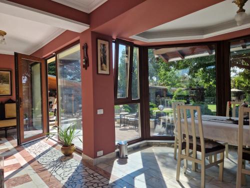 a room with large windows and a table and chairs at CASA IANUȘ in Breaza