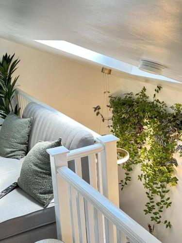 a living room with a couch and a plant at Cosy Stylish Studio Apartment in Trowbridge