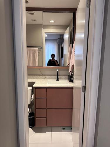 a man taking a picture of a bathroom mirror at Studio Chácara Sto Antonio in Sao Paulo
