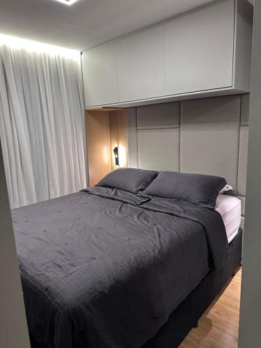 a bedroom with a large bed and a white cabinet at Studio Chácara Sto Antonio in Sao Paulo