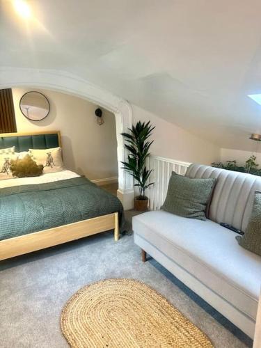 a bedroom with a bed and a couch at Cosy Stylish Studio Apartment in Trowbridge