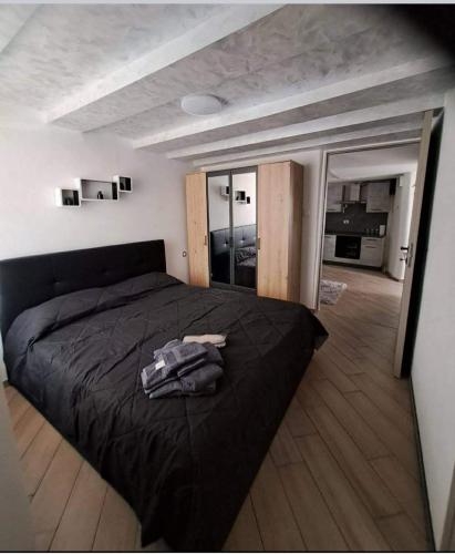 sypialnia z czarnym łóżkiem i dużym oknem w obiekcie Casa Jasmina w mieście Mezzano