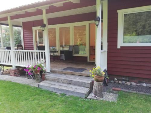un porche delantero de una casa con flores. en Gästehaus an der Surheide en Ottersberg