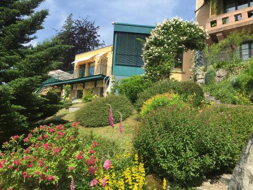 a garden with flowers in front of a building at Le Manoir Au Lac in Gérardmer