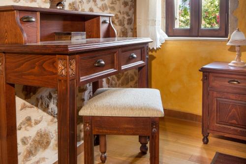 a wooden desk with a chair next to a table at Samonas Traditional Villas in Samonás