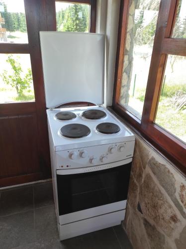 a white stove in a room with two windows at Orange House in nature in Žabljak