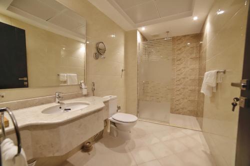 a bathroom with a sink and a toilet and a shower at فندق زوايا الماسية(العوالي) in Al Madinah