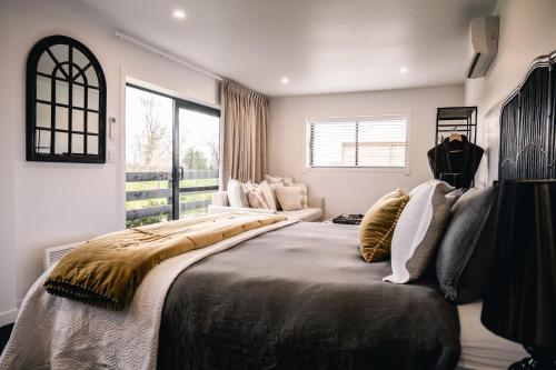 a bedroom with a large bed and a large window at Matamata Country B&B in Matamata