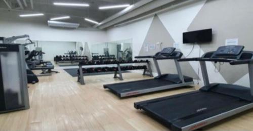 a gym with several treadmills and machines in a room at Minimalist Condo Studio City Tower 2 Filinvest Alabang Muntinlupa in Manila
