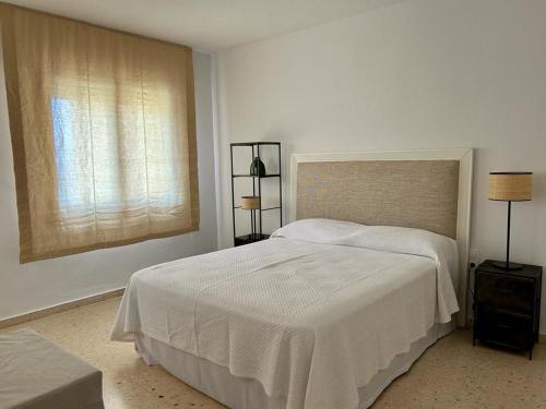une chambre blanche avec un lit et une fenêtre dans l'établissement APARTAMENTO CALAFLORES, à Cap de Palos