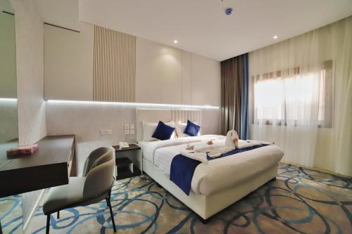 Habitación de hotel con cama grande, escritorio y silla en فندق زوايا الماسية(العوالي), en Medina