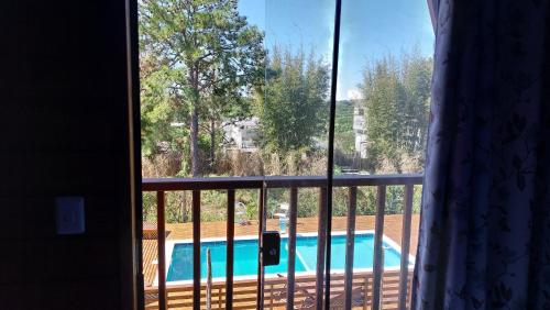 a view of a swimming pool from a window at Chalés Ilha da Mata Pousada in Florianópolis